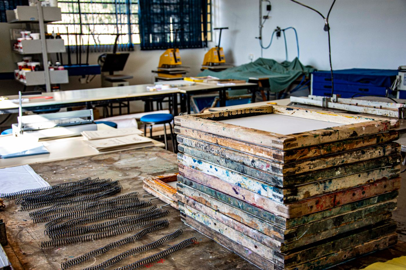A stack of ink-stained wooden screen frames in a workshop