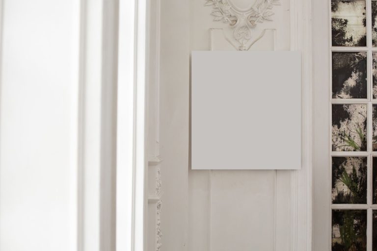 A blank canvas hanging on a light decorated wall